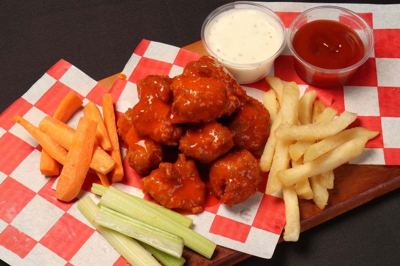 about-01 Tasty buffalo wings with vegetables and fries, perfect for a snack or party platter.