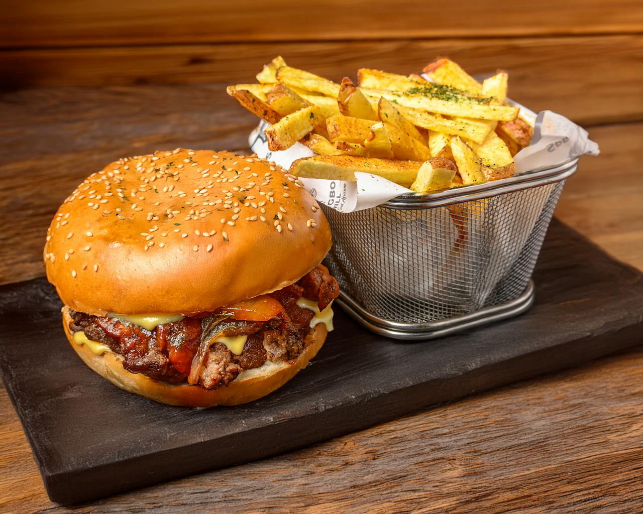 services-01 Tantalizing gourmet burger with crispy fries served on a slate board highlighting a rustic dining experience.
