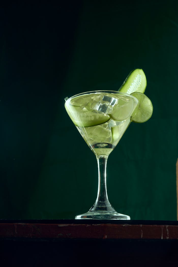 gallery-3 Elegant cocktail with green garnish in a stylish glass against a dark background.