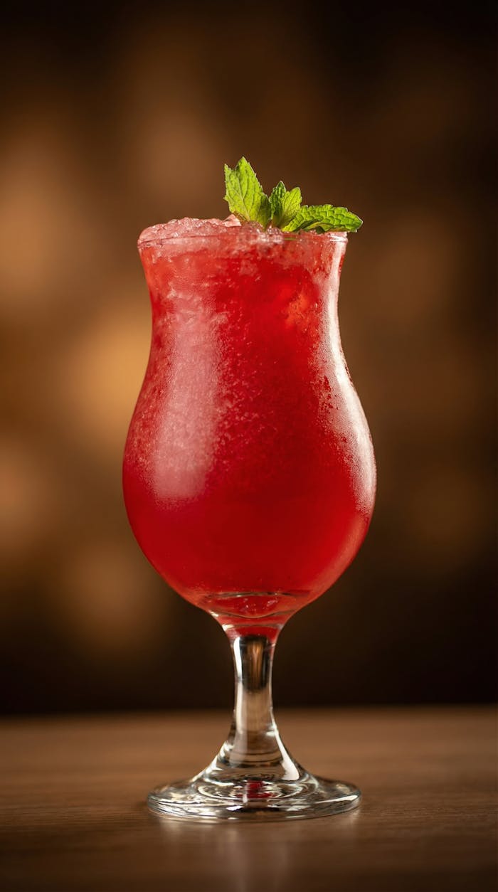 gallery-4 Delightful red berry cocktail topped with fresh mint, ideal for tropical settings.